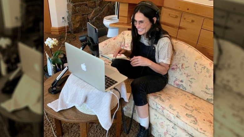 Demi Moore on her laptop in her carpeted bathroom