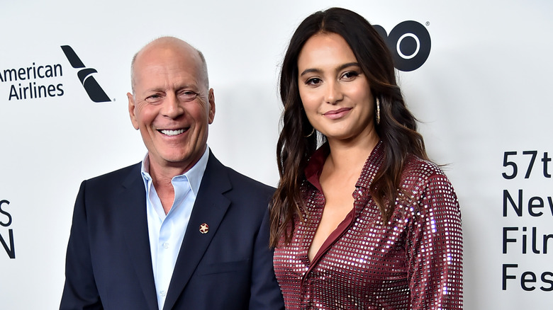 Emma and Bruce Willis pose for cameras on a red carpet