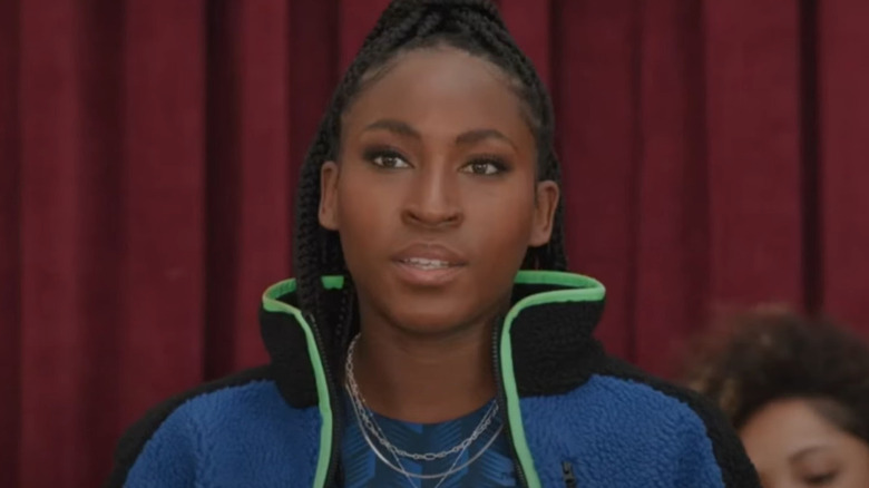 Coco Gauff speaking front of red curtain