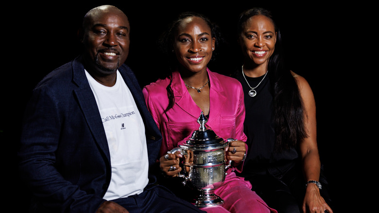 Coco Gauff and her parents posing with trophy