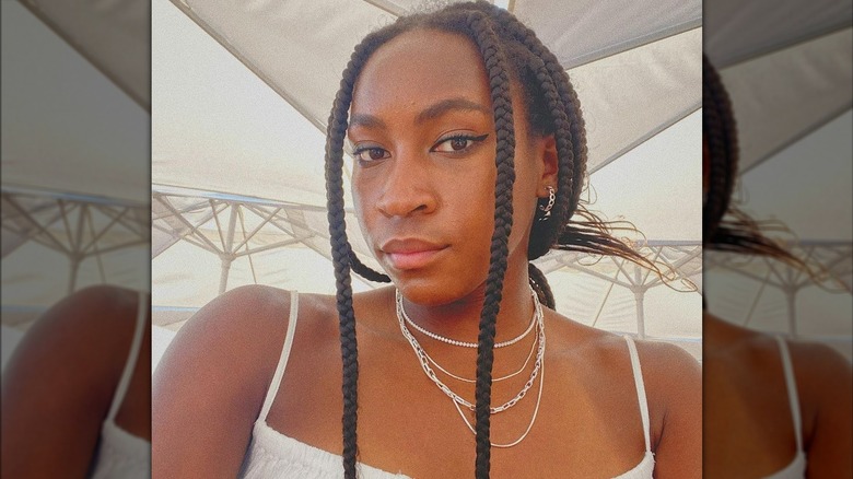 Coco Gauff posing wearing stacked necklaces