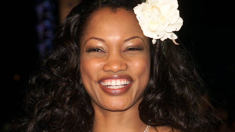 Garcelle Beauvais smiling with a flower in her hair