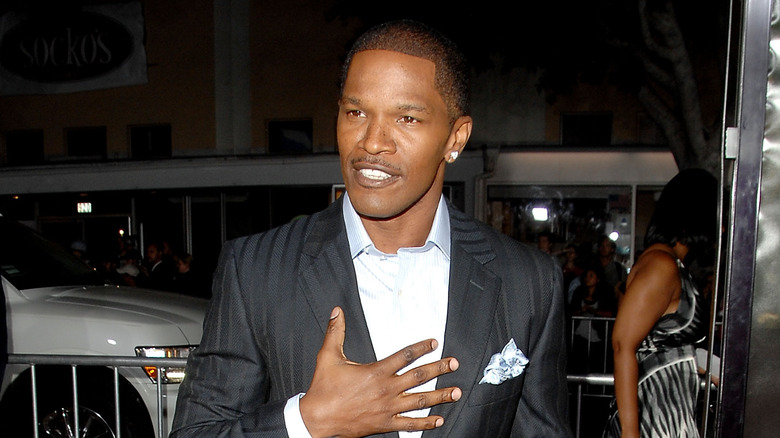 Jamie Foxx posing for photo in black suit