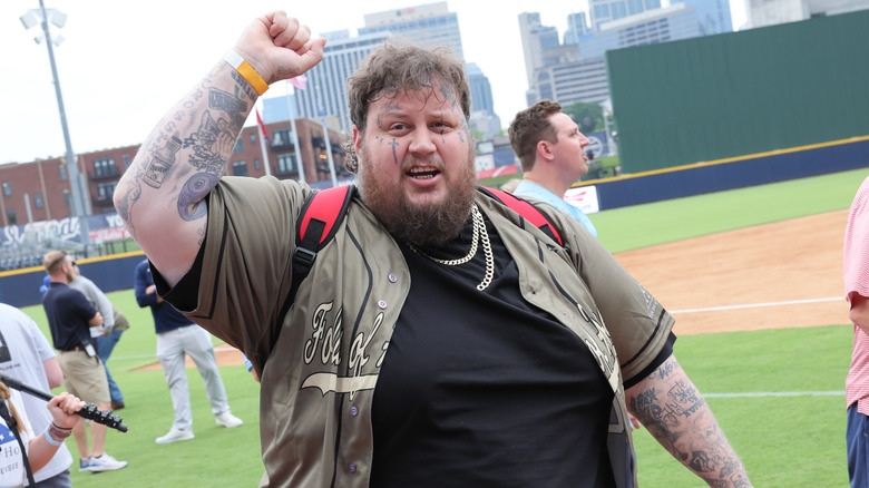 Jelly Roll raising his arm at baseball game 