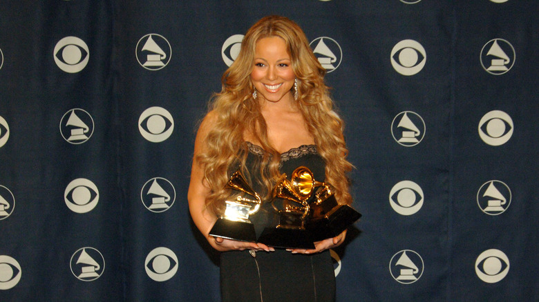 Mariah Carey holding multiple Grammy Awards