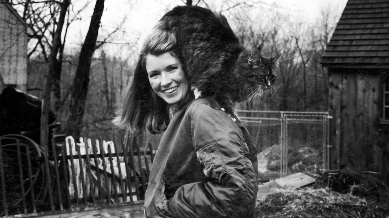 Martha Stewart smiling with her cat on her shoulders in 1980