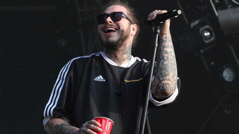 Post Malone performing with a red cup in hand