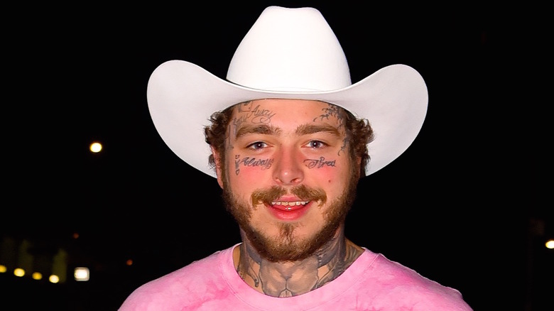 Post Malone smiling with a cowboy hat on