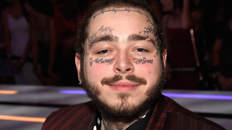 Post Malone smiling with face tattoos