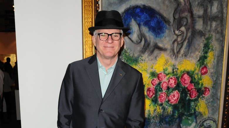 Steve Martin posing with a painting