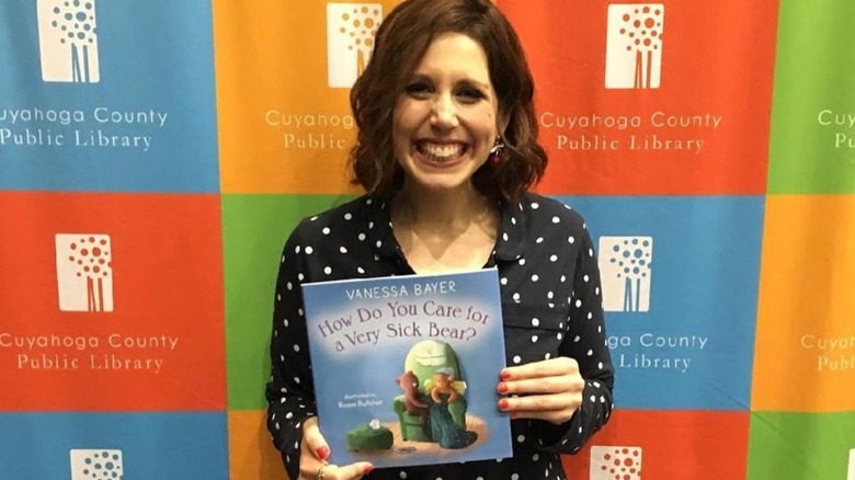 Vanessa Bayer smiling with her book