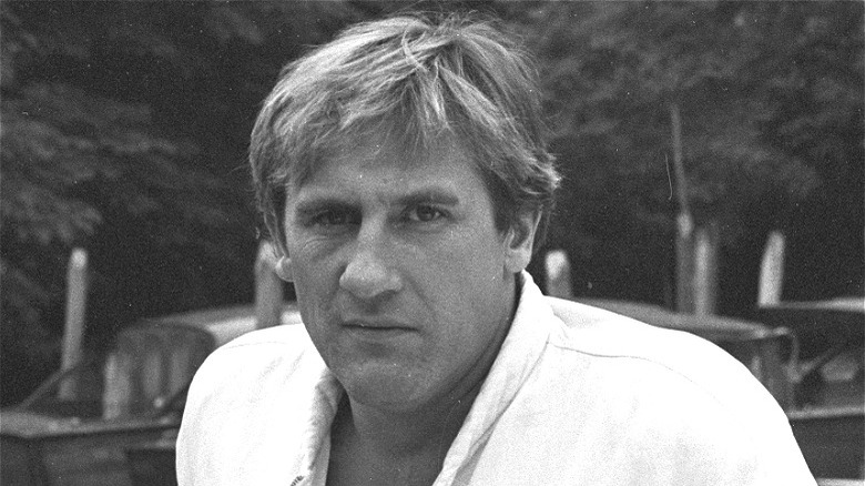 Gerard Depardieu posing by boats 