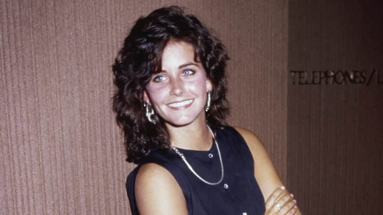 Courteney Cox smiling and posing in 1987