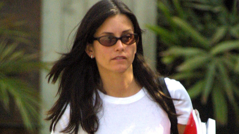 Courteney Cox walking with sunglasses on in 2001