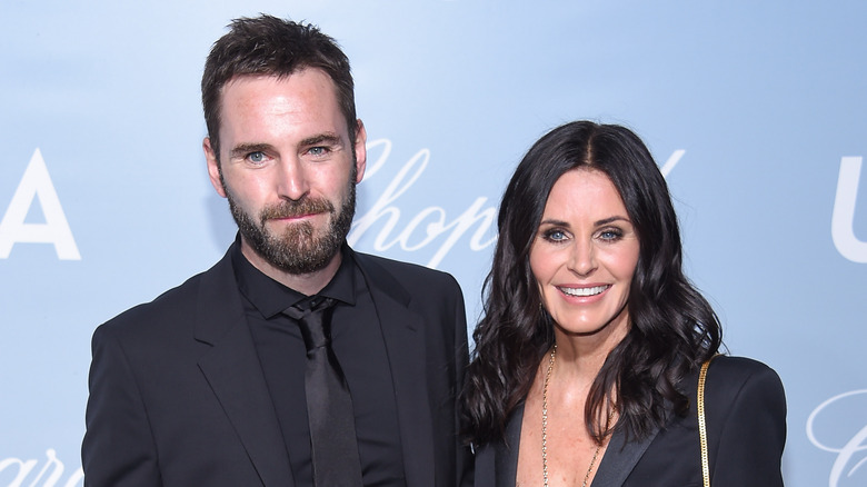 Johnny McDaid and Courteney Cox posing and smiling