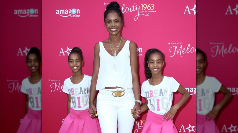 Kim Porter posing with her twin daughters.