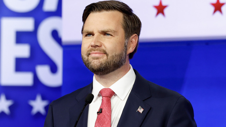 JD Vance smiling on stage at an event.