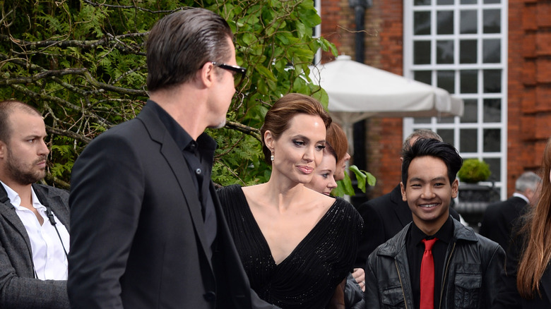 Brad Pitt looking back at Angelina Jolie and Maddox Jolie-Pitt