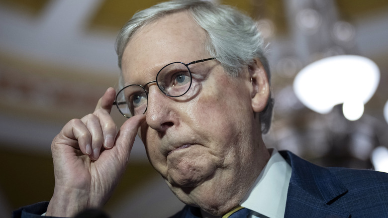 Mitch McConnell holding his glasses