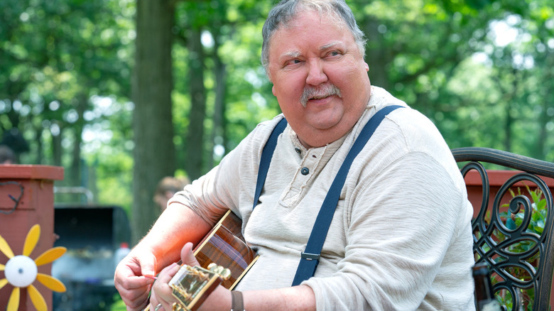 Mike Hagerty smiling and playing the guitar