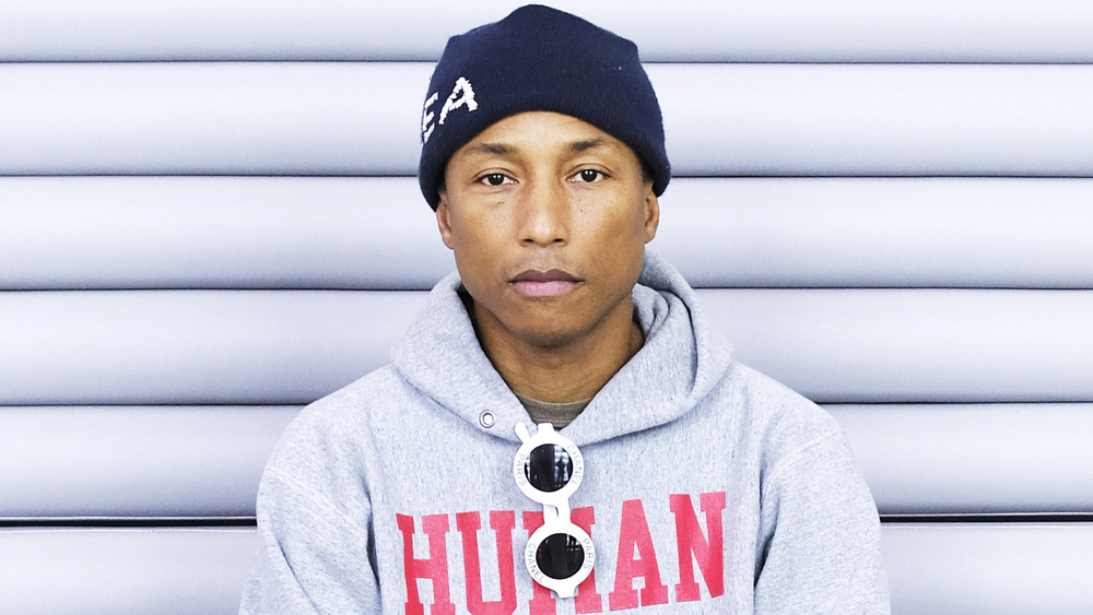 Pharrell Williams sitting down and gazing at the camera