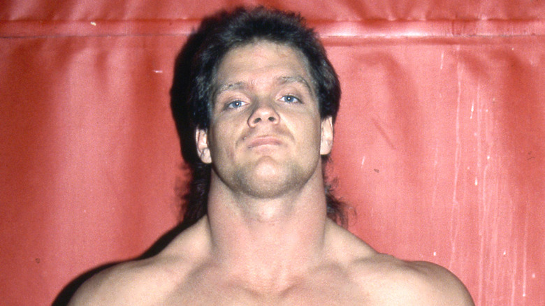 Chris Benoit posing in his wrestling gear in his younger days