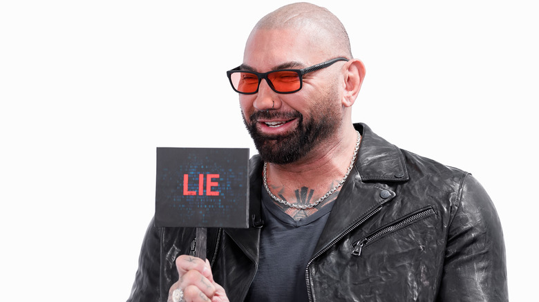 Dave Bautista holding up a sign that says "lie"