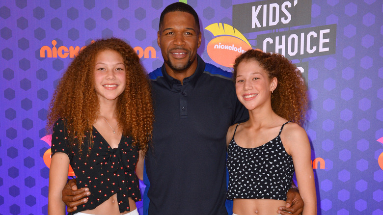 Michael Strahan posing with daughters Sophia and Isabella