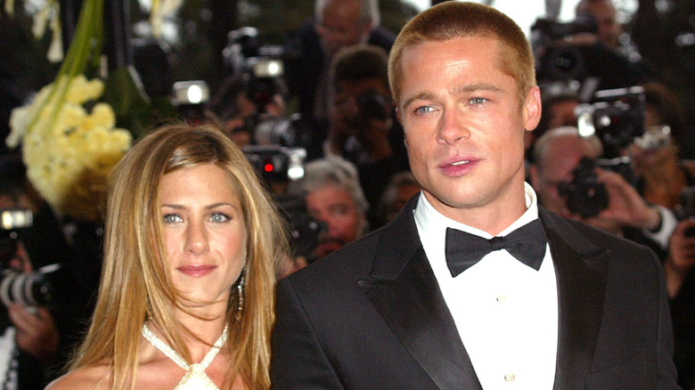 Jennifer Aniston wearing a criss-cross dress and Brad Pitt wearing a black tuxedo and bow tie