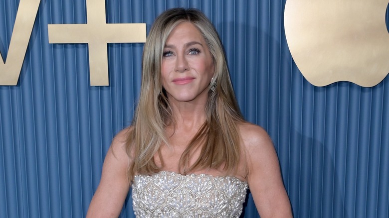 Jennifer Aniston wearing a strapless silver gown with beaded overlay