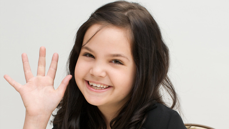 Bailee Madison smiling and waving as a child