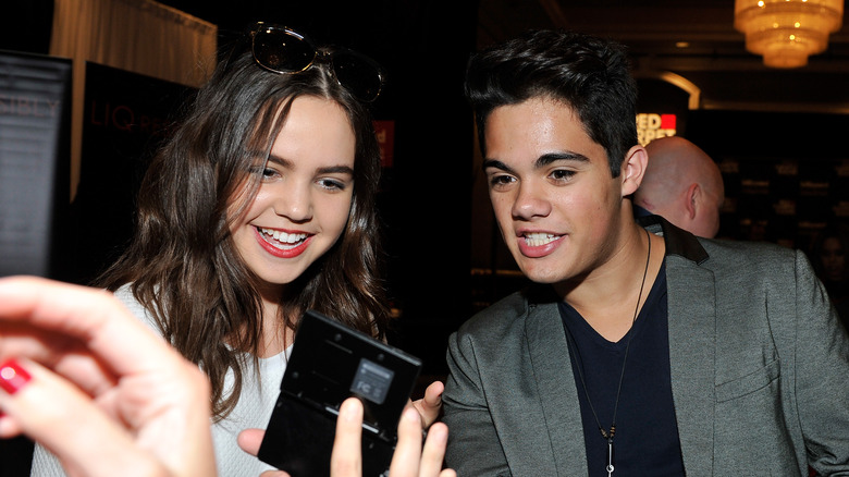 Bailee Madison looking down at a phone with Emery Kelly