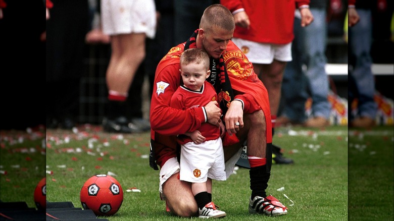 David Beckham with Brooklyn on a soccer field in 2001