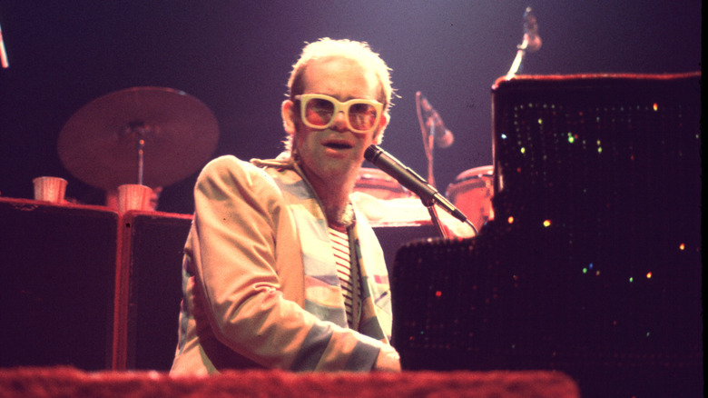 Elton John playing piano on stage