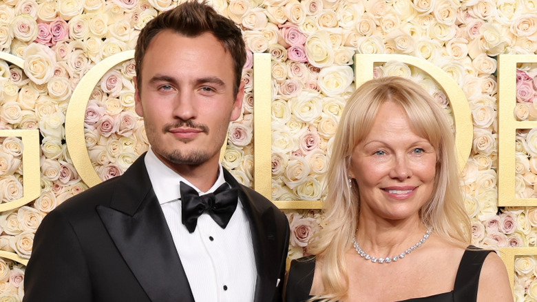 Brandon Thomas Lee and Pamela Anderson pose together at the 2025 Golden Globes