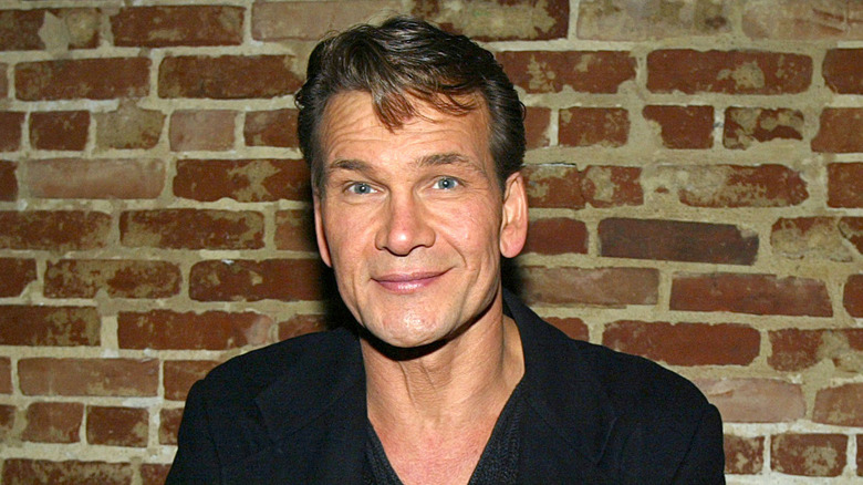 Patrick Swayze smiling brick wall