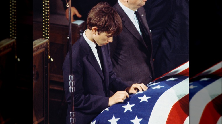 Robert F. Kennedy Jr. placing his hands on the coffin of his father