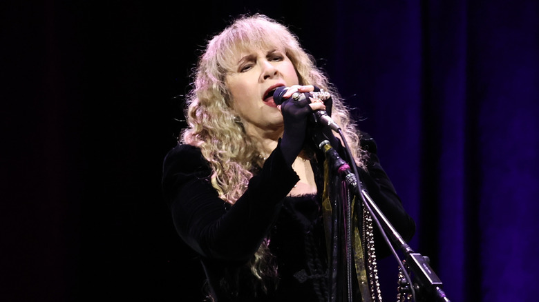 Stevie Nicks singing in a black long-sleeved dress