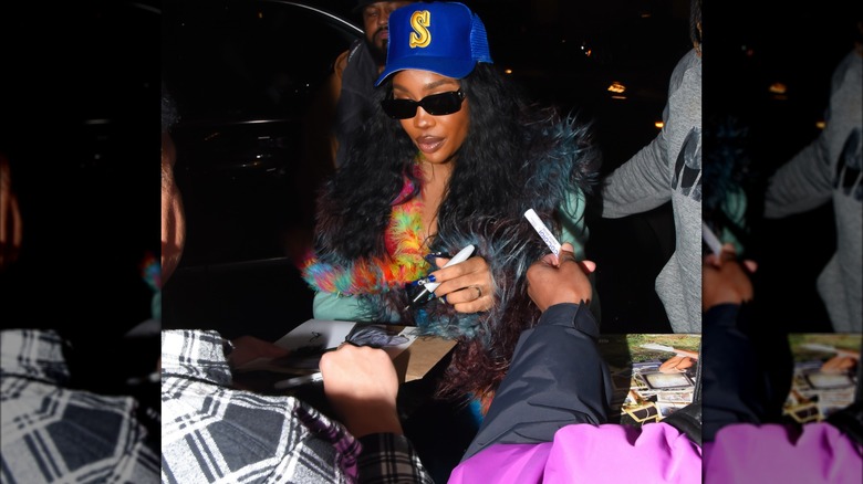 SZA signing autographs for fans.