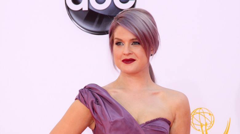 Kelly Osbourne standing in violet dress