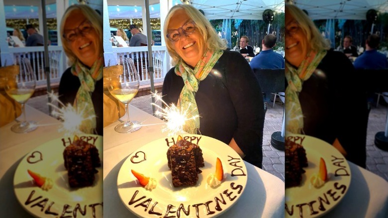 Kathy Doocy poses in front of a cake