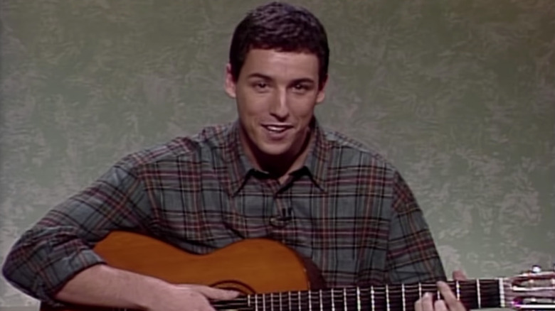 Adam Sandler holding guitar on SNL in 1992