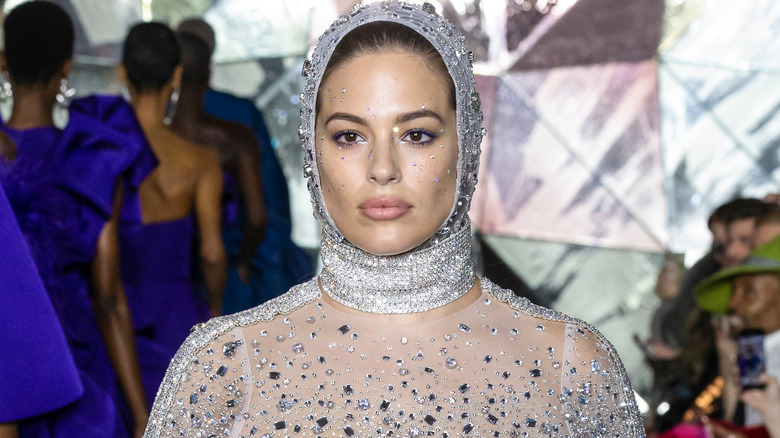 Ashley Graham walking the catwalk in glittery gown and headdress