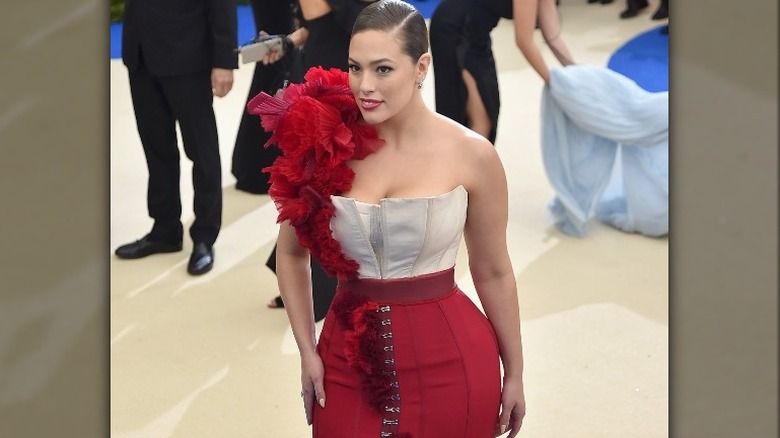 Ashley Graham posing in red and white Met Gala gown