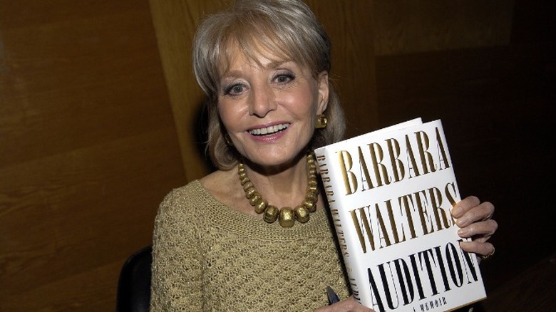 Barbara Walters holding book