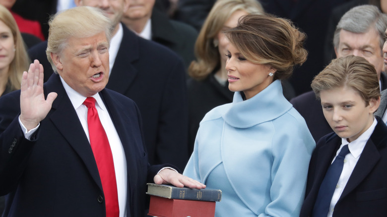 Donald Trump with hand on Bible beside family