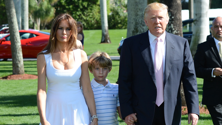 Barron, Donald and Melania Trump outdoors