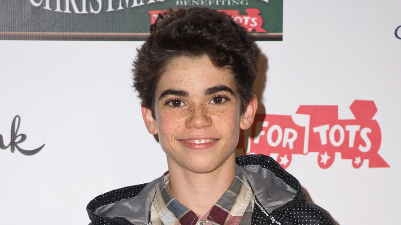 Cameron Boyce poses for a photo in hoodie and plaid shirt