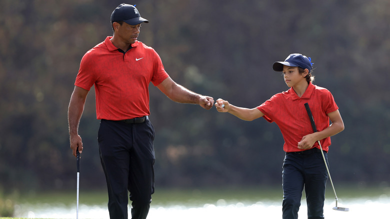 Tiger and Charlie Woods fist bump on the course