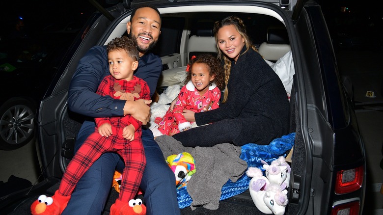 John Legend and Chrissy Teigen holding Miles and Luna